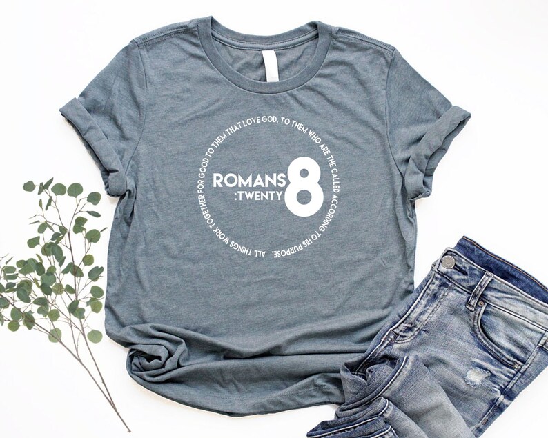 May include: A heather grey t-shirt with a white circle graphic featuring the text "Romans 8: Twenty" and the number "8" in a large font.