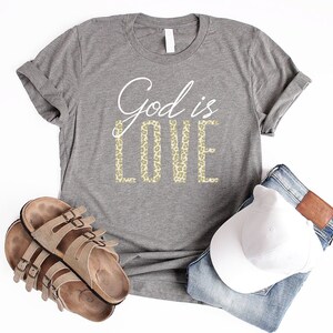 May include: A gray t-shirt with the text "God is Love" in white and gold leopard print lettering.