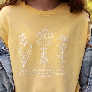 May include: Yellow t-shirt with a white floral design and the text "grow in the grace and knowledge of our Lord and Savior Jesus Christ 2 Peter 3:18"