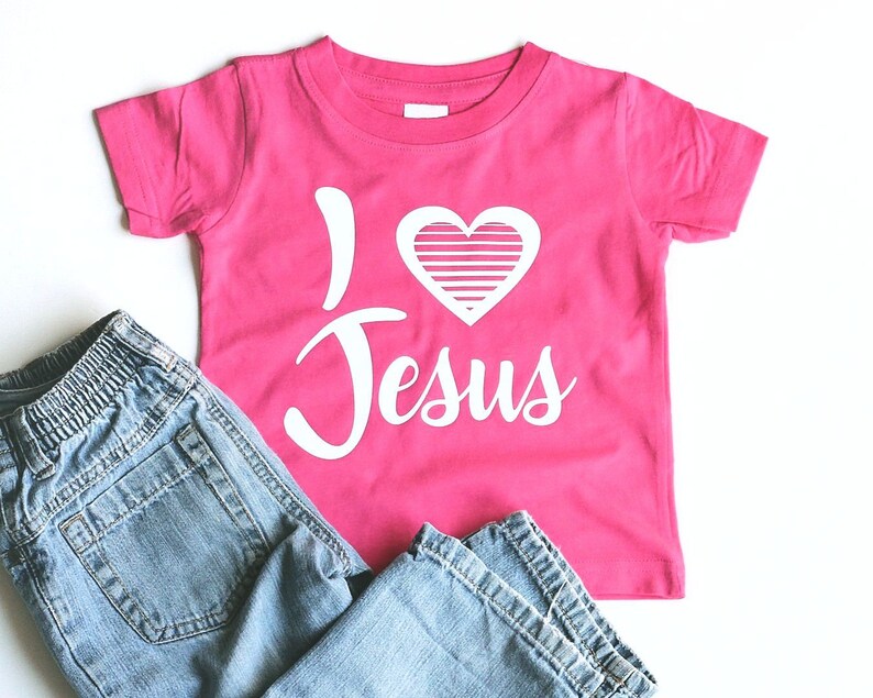 May include: Pink t-shirt with a white heart and the words "I love Jesus" printed on it.