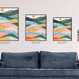 Op de afbeelding: Vier ingelijste prints van een kleurrijk landschap met glooiende heuvels, groene bomen en een gele zon. De prints zijn in verschillende formaten: 24x30 inch, 18x24 inch, 16x20 inch en 8x10 inch.