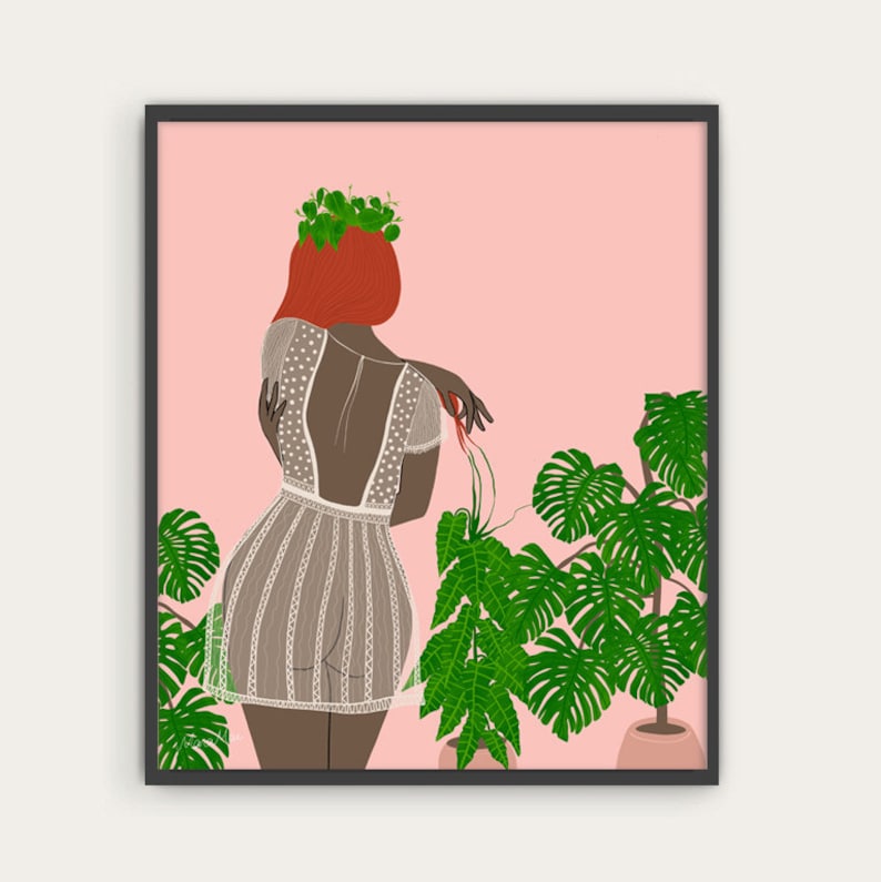 Op de afbeelding: Een vrouw met rood haar en een bloemenkrans draagt een witte kanten jurk en staat voor een roze achtergrond met groene planten.