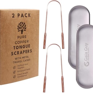Puede incluir: Un juego de dos raspadores de lengua de cobre rosa con estuches de viaje de metal. El embalaje presenta el nombre de la marca Gaia Guy y el texto "From Earth. For Earth." El embalaje también incluye el texto "2 PACK", "PURE COPPER TONGUE SCRAPERS", "WITH METAL TRAVEL CASES", "Optimal Oral Hygiene", "Enhanced Taste", "Fresh Breath", "Confidence", y "If you have concerns or questions email ian@gaiaguy.com or visit GaiaGuy.com".