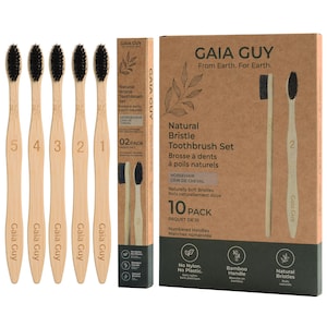 Könnte beinhalten: Ein 10er-Pack Gaia Guy Zahnbürsten mit Naturborsten, hellen Bambusgriffen und schwarzen Borsten. Jeder Griff ist von 1 bis 5 nummeriert. Das Set enthält eine hohe rechteckige Schachtel und eine schmale vertikale Schachtel aus braunem Karton.
