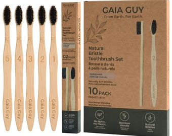 Puede incluir: Un paquete de 10 cepillos de dientes Gaia Guy de cerdas naturales con mangos de bambú claro y cerdas negras. Cada mango está numerado del 1 al 5. El set incluye una caja rectangular alta y una caja vertical delgada de cartón marrón.