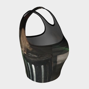 May include: Black and green crop top with a graphic print of a trash can with white stripes.