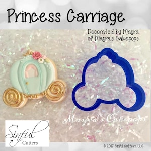 May include: A princess carriage cookie cutter and a decorated cookie. The cookie is light blue with gold accents and floral decorations. The cutter is blue plastic. Text on the image includes "Princess Carriage" and "Decorated by Mayra of Mayra's Cakepops."