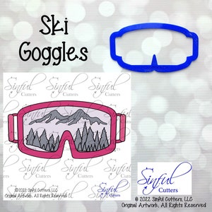 May include: Pink ski goggles with a mountain and forest scene inside the lenses. The text "Ski Goggles" is above the image. A blue outline of the goggles is shown to the right of the image. The text "Sinful Cutters" is at the bottom of the image.