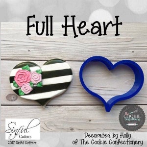 Puede incluir: Un cortador de galletas de plástico azul en forma de corazón, junto a una galleta decorada en forma de corazón con rayas blancas y negras y rosas rosas. El texto "Full Heart" está en la parte superior de la imagen. El texto "Sinful Cutters 2017 Sinful Cutters" está en la parte inferior izquierda de la imagen. El texto "the COOKIE Confectionery" está en la parte inferior derecha de la imagen. El texto "Decorated by Holly of The Cookie Confectionery" está en la parte inferior central de la imagen.