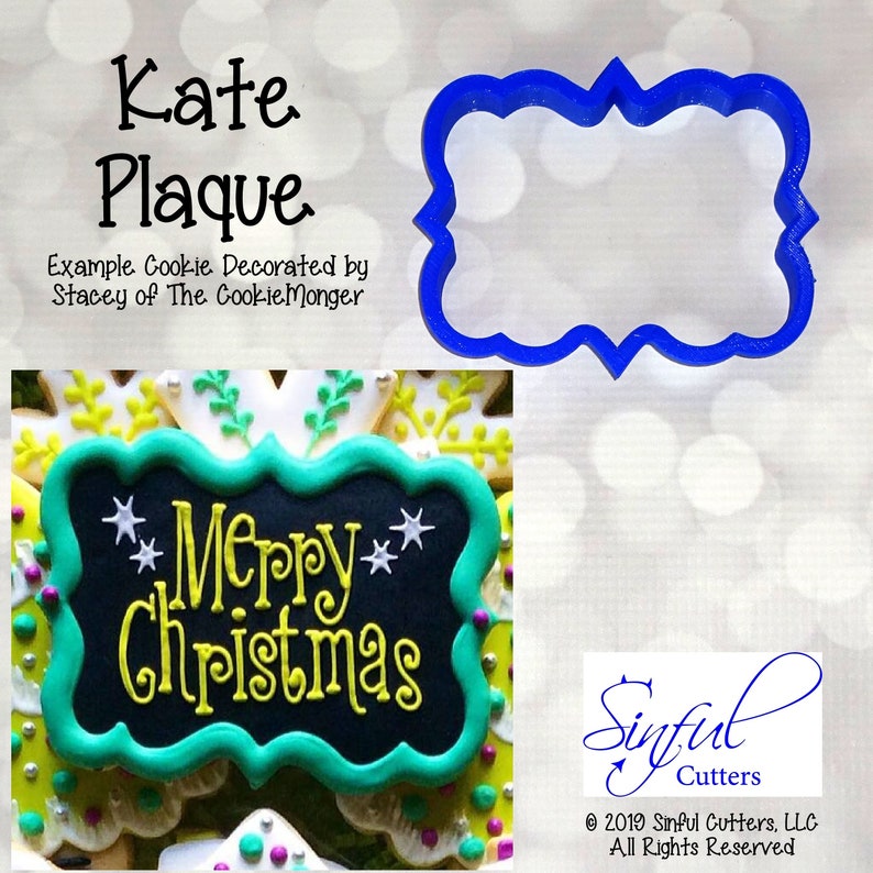 May include: A blue plastic cookie cutter in a plaque shape with a decorative border. The image also shows an example cookie decorated with the words "Merry Christmas" in yellow and white icing. Text on the image reads "Kate Plaque".