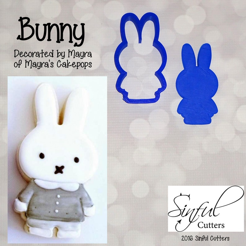 May include: A blue plastic cookie cutter shaped like a bunny rabbit. The cutter is shown next to a decorated cookie of a bunny rabbit wearing a gray shirt. The text "Bunny" is at the top of the image and "Decorated by Mayra of Mayra's Cakepops" is below it. The text "Sinful Cutters 2016 Sinful Cutters" is at the bottom of the image.
