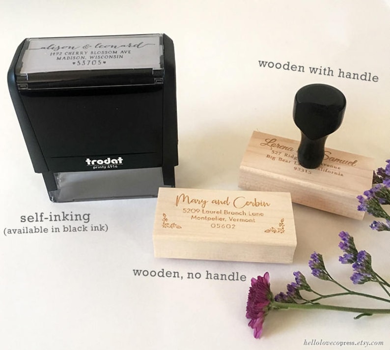 May include: Three wooden return address stamps with different styles. The first stamp is self-inking and black. The second stamp is wooden with a handle. The third stamp is wooden without a handle.