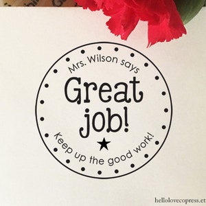 May include: Black and white round sticker with the text "Mrs. Wilson says Great job! Keep up the good work!" and a star in the centre.