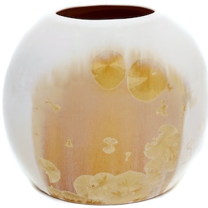 May include: A white ceramic vase with a round shape and a subtle ombre effect transitioning from white to a light brown. The vase features a delicate pattern of yellow floral designs.
