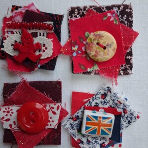 May include: Four square fabric patches featuring layered textiles in red, white, and dark tones. Embellishments include a red gingerbread-shaped figure, a floral-patterned button, a solid red button, and a rectangular button with a Union Jack flag.