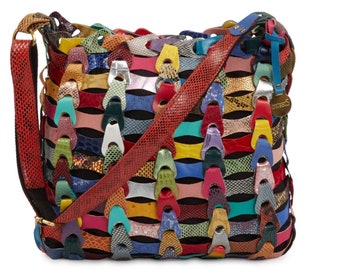 Puede incluir: Un bolso de hombro de cuero multicolor con una correa de piel de serpiente. El bolso está hecho de diferentes piezas de cuero de colores cosidas juntas en un patrón tejido.