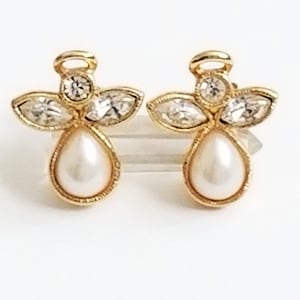 May include: A pair of gold angel-shaped earrings with a pearl drop and clear crystal accents.
