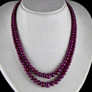 May include: A double strand necklace made of deep purple ruby beads.