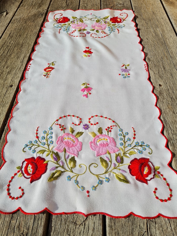 ヴィンテージの手刺繍のテーブルランナー。カラフルな花が刺繍された