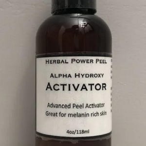 May include: A brown bottle with a black cap, labeled "HERBAL POWER PEEL ALPHA HYDROXY ACTIVATOR." The label also states "Advanced Peel Activator Great for melanin rich skin." The bottle contains 4oz/118ml of product.