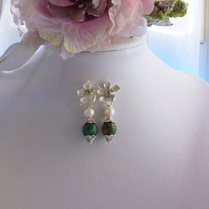 Può includere: Orecchini a forma di fiore in argento con perline di agata verde e marrone e dettagli di perle bianche.
