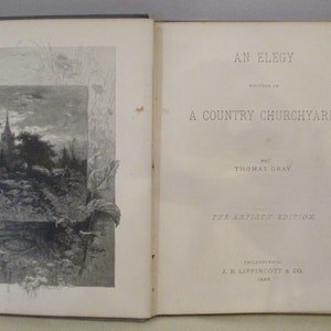 May include: An open book with a black and white illustration of a country churchyard on the left page. The right page has the title "An Elegy Written in a Country Churchyard" by Thomas Gray. The book is from the Artists' Edition, published by J.B. Lippincott & Co. in 1888.
