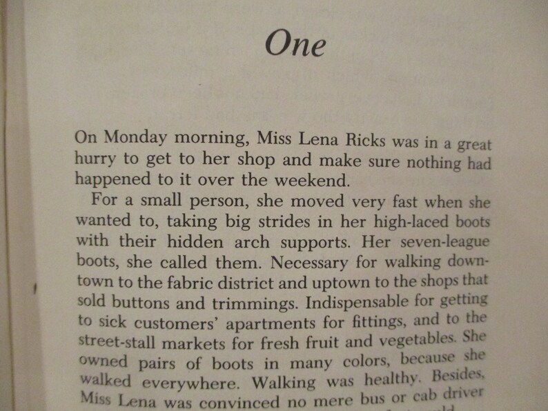Puede incluir: Una p&aacute;gina de un libro con la palabra "Uno" como t&iacute;tulo. El texto describe a una mujer llamada Miss Lena Ricks que tiene prisa por llegar a su tienda. Ella camina a todas partes y est&aacute; convencida de que ning&uacute;n autob&uacute;s o taxi puede llevarla all&iacute; tan r&aacute;pido como ella puede caminar.