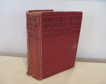 Puede incluir: Un libro antiguo de tapa dura, titulado "History of the World War", con una cubierta roja. El título y el autor están impresos en negro. El libro está de pie, mostrando el lomo y la portada.