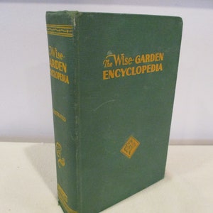 Puede incluir: Un libro de tapa dura verde titulado "The Wise-Garden Encyclopedia". El libro tiene letras doradas y una ilustraci&oacute;n dorada de una flor en la portada.