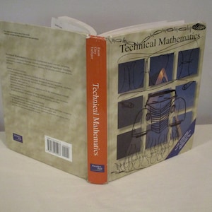 May include: A closed textbook titled "Technical Mathematics" by Ewen  Gary  Tredgold. The cover features a blue and white illustration of a car with flames.