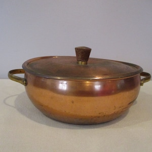 Peut inclure: Une casserole en cuivre avec des poignées en laiton et un bouton en bois sur le couvercle.