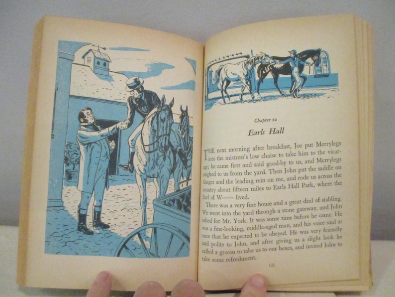 May include: Open book with illustrations in blue and white. One illustration shows a man on horseback, another shows horses in a stable. Text on the right page reads "Chapter 23 Earls Hall".