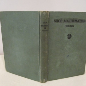 May include: A green hardcover book titled "Shop Mathematics" by Holton. The book has a globe symbol on the front cover.