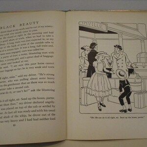 May include: An open book with text and a black and white illustration. The illustration depicts a scene at a train station with people and luggage. The text on the left page is from "Black Beauty".