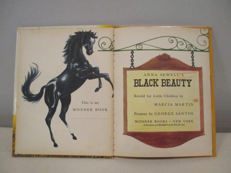 May include: Open book with a black horse illustration on the left page and text on the right. The book is titled "Black Beauty" by Anna Sewell, retold for children. The book is part of the Wonder Books series.