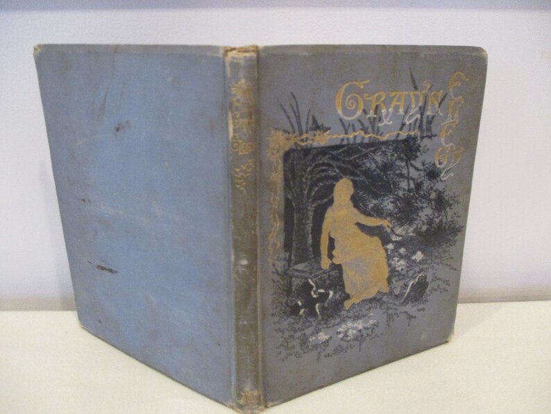 May include: A blue book with gold lettering on the cover. The title of the book is "Graving for the  " and the cover features a black and white illustration of a woman in a woodland setting.