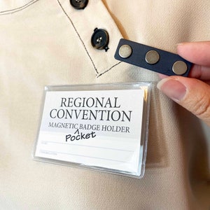 May include: A white badge holder with the text "REGIONAL CONVENTION MAGNETIC BADGE HOLDER Pocket" and blank lines for "NAME" and "ORGANIZATION".