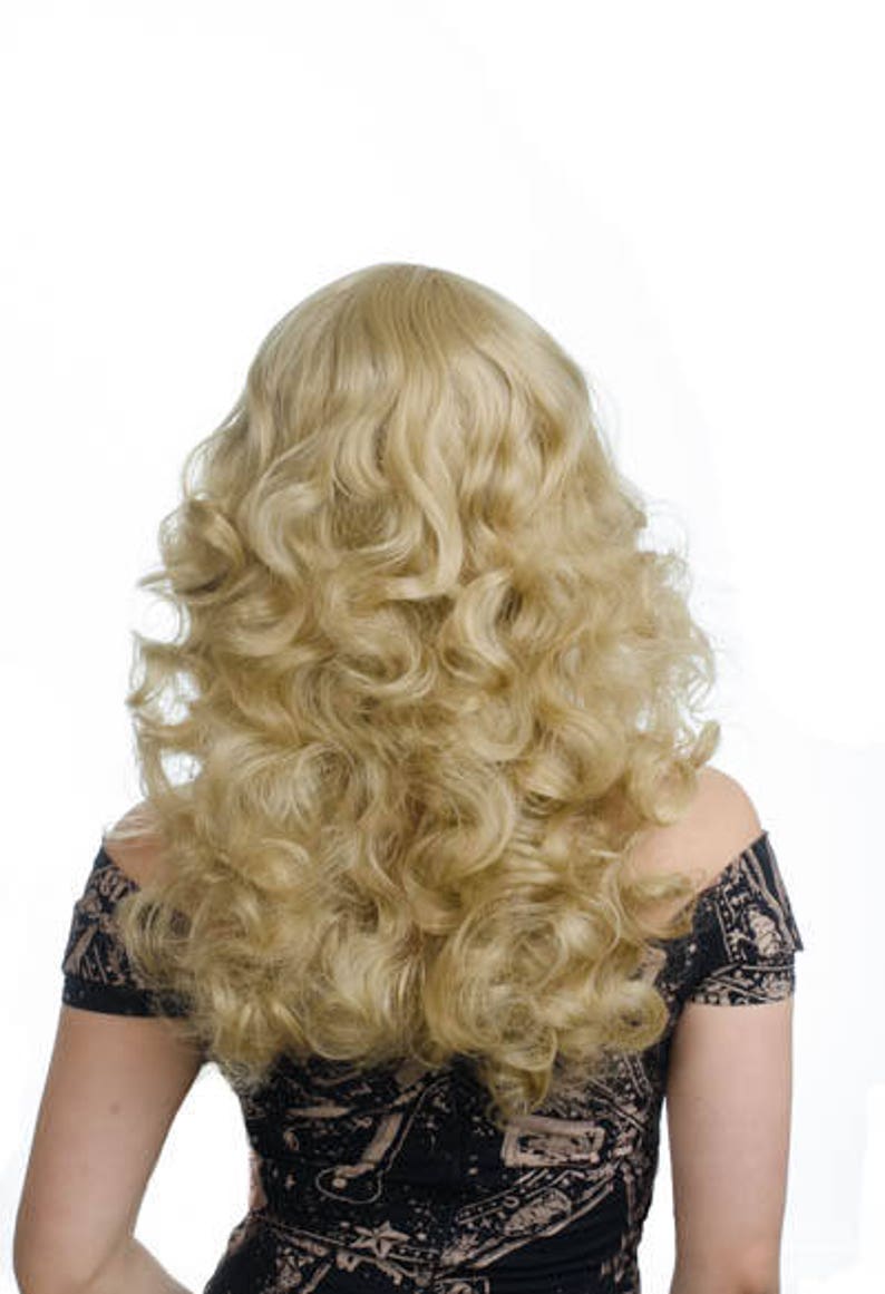 Pode incluir: Uma peruca longa e loira com cachos soltos. A peruca est&aacute; penteada com um estilo cl&aacute;ssico dos anos 70.