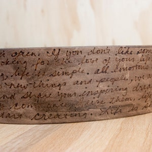 Puede incluir: Un brazalete de cuero marrón con un mensaje escrito a mano que dice: "1, y hazlo abierto. Si no te gusta algo, estás buscando el amor de tu vida, deja de analizar, la vida es simple, todo. las emociones son nuevas y el corazón a cosas nuevas y personas, somos misión es y da forma a tus sueños inspiradores y solo ven y apáñalos, la vida es para y comienza a crear. La vida es show"
