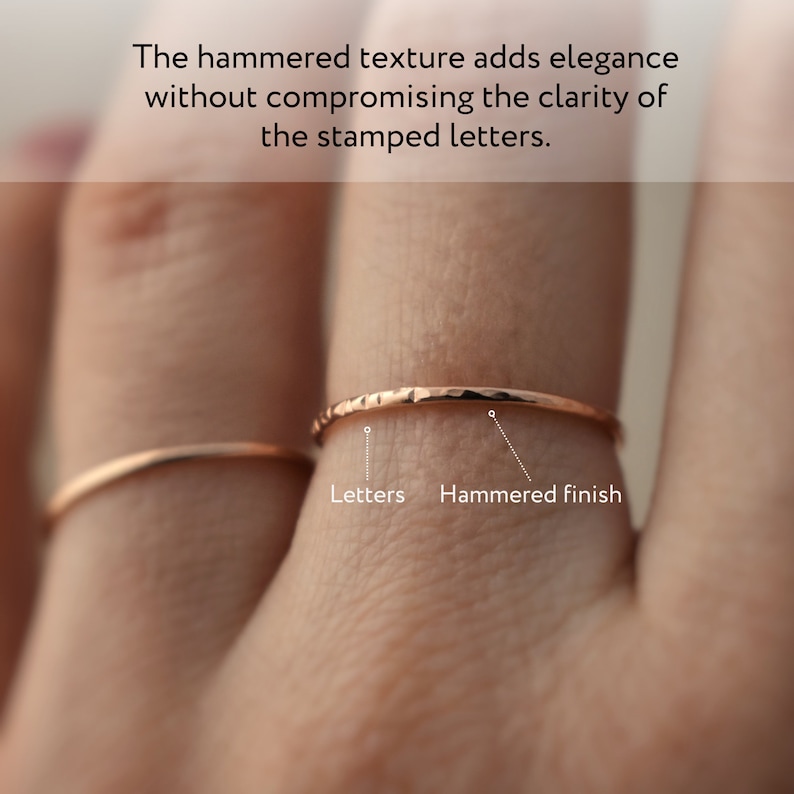 Puede incluir: Dos anillos de oro en un dedo. El anillo superior tiene un acabado martillado, mientras que el anillo inferior es liso. El texto "Letters" y "Hammered finish" est&aacute; etiquetado debajo de los anillos.