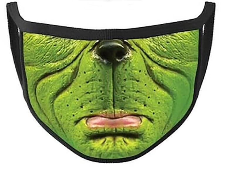 May include: Green face mask with a cartoon-like face, featuring a large nose, wrinkled forehead, and a frowning mouth. The mask is made of a soft, breathable fabric and has adjustable ear loops.