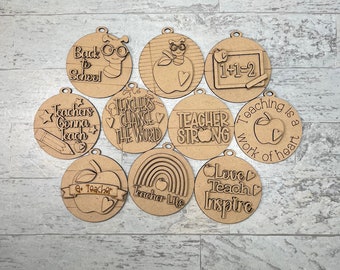 May include: Ten round wooden ornaments with various teacher-themed designs, including "Back to School", "Teachers Gonna Teach", "Teachers Change the World", "Teacher Strong", "Teaching is a Work of Heart", "1+1=2", "Love Teach Inspire", "Teacher Life", and "#1 Teacher".