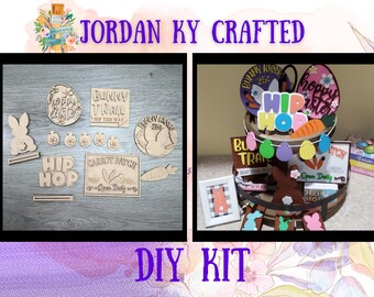 May include: A DIY kit for an Easter-themed tiered tray featuring wooden cutouts with bunny, carrot, and egg designs. The kit includes a sign that says "Bunny Trail Hop This Way", a sign that says "Carrot Patch Open Daily", and a sign that says "Hip Hop".