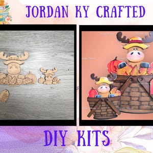 May include: Two wooden moose figures with pumpkins and leaves, and a tag. The moose are light brown and the pumpkins are orange. The text "JORDAN KY CRAFTED" and "DIY KITS" are visible.