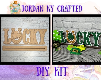 May include: A DIY kit for a wooden "Lucky" sign with a horseshoe and shamrock. The kit includes the unfinished wood pieces and a wooden dowel for hanging. The sign is shown in both unfinished and painted states.