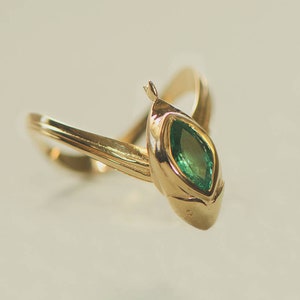 Puede incluir: Un anillo de oro con una esmeralda de forma marquesa engastada en garras.