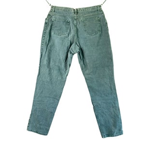 May include: A pair of dark green denim jeans with a straight leg and five pockets.