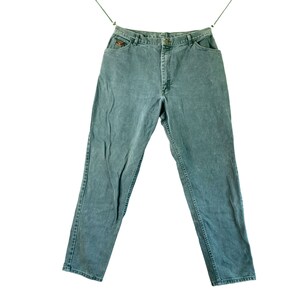 May include: A pair of blue denim jeans hanging on a clothesline. The jeans have a straight leg and a classic five-pocket design.