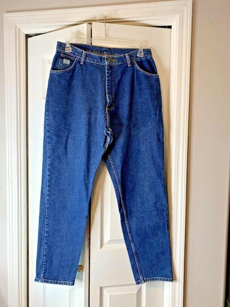 May include: A pair of blue denim jeans with a straight leg fit. The jeans have a button fly and belt loops.