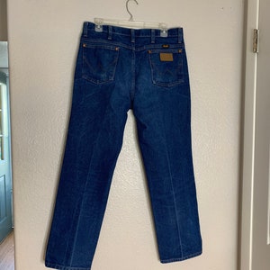 May include: A pair of blue denim jeans with a brown leather patch on the back pocket.